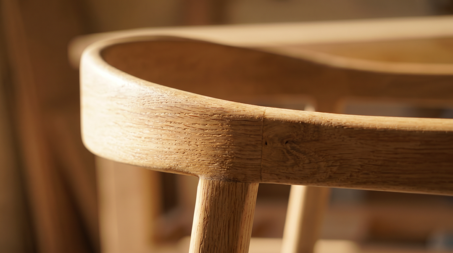 Close-up of the Brigitte dining chair joinery, showing the solid wood leg-to-seat joint and grey boucle seat